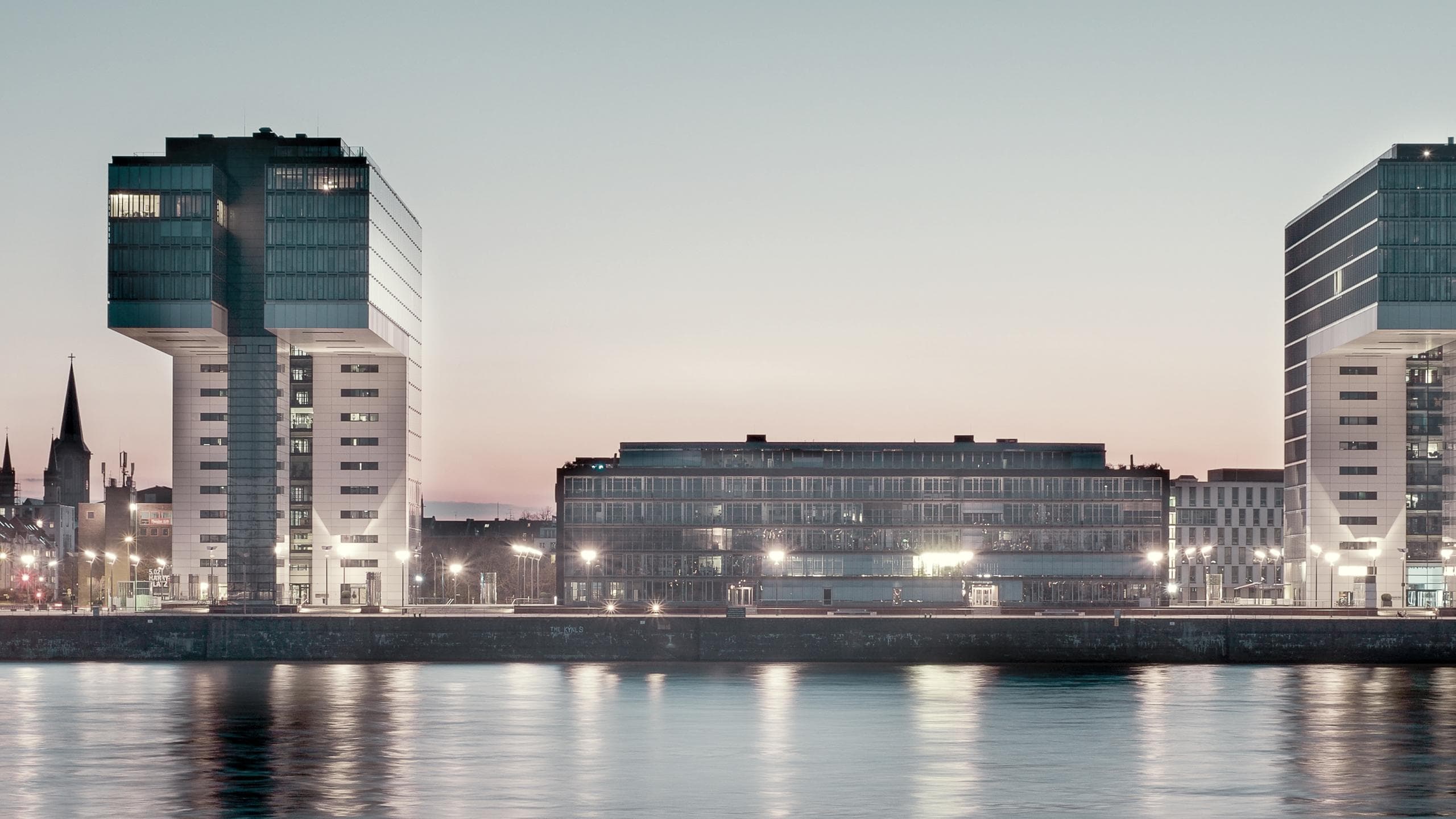 Kranhäuser von der Rheinseite im Kölner Rheinauhafen am Abend